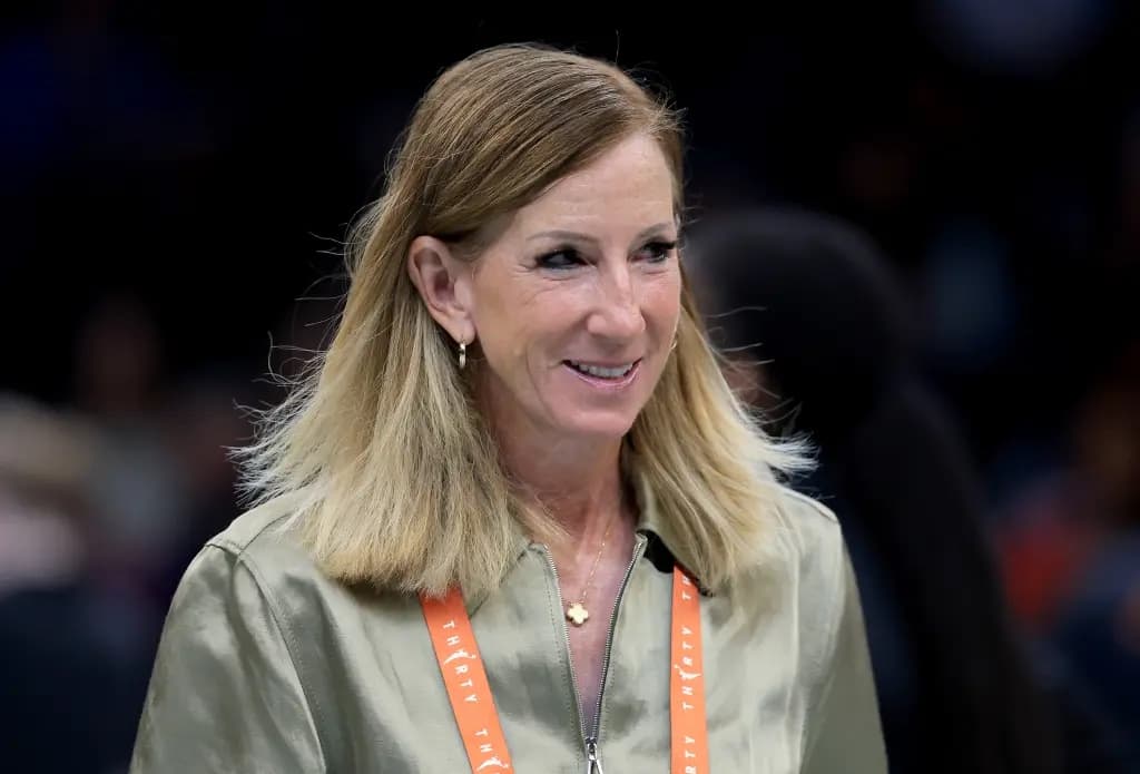 Cathy Engelbert smiling courtside wearing an orange lanyard