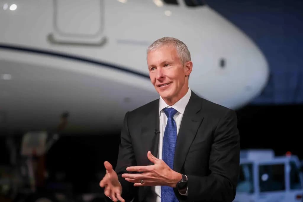 Scott Kirby gesturing while speaking in front of an aircraft nose