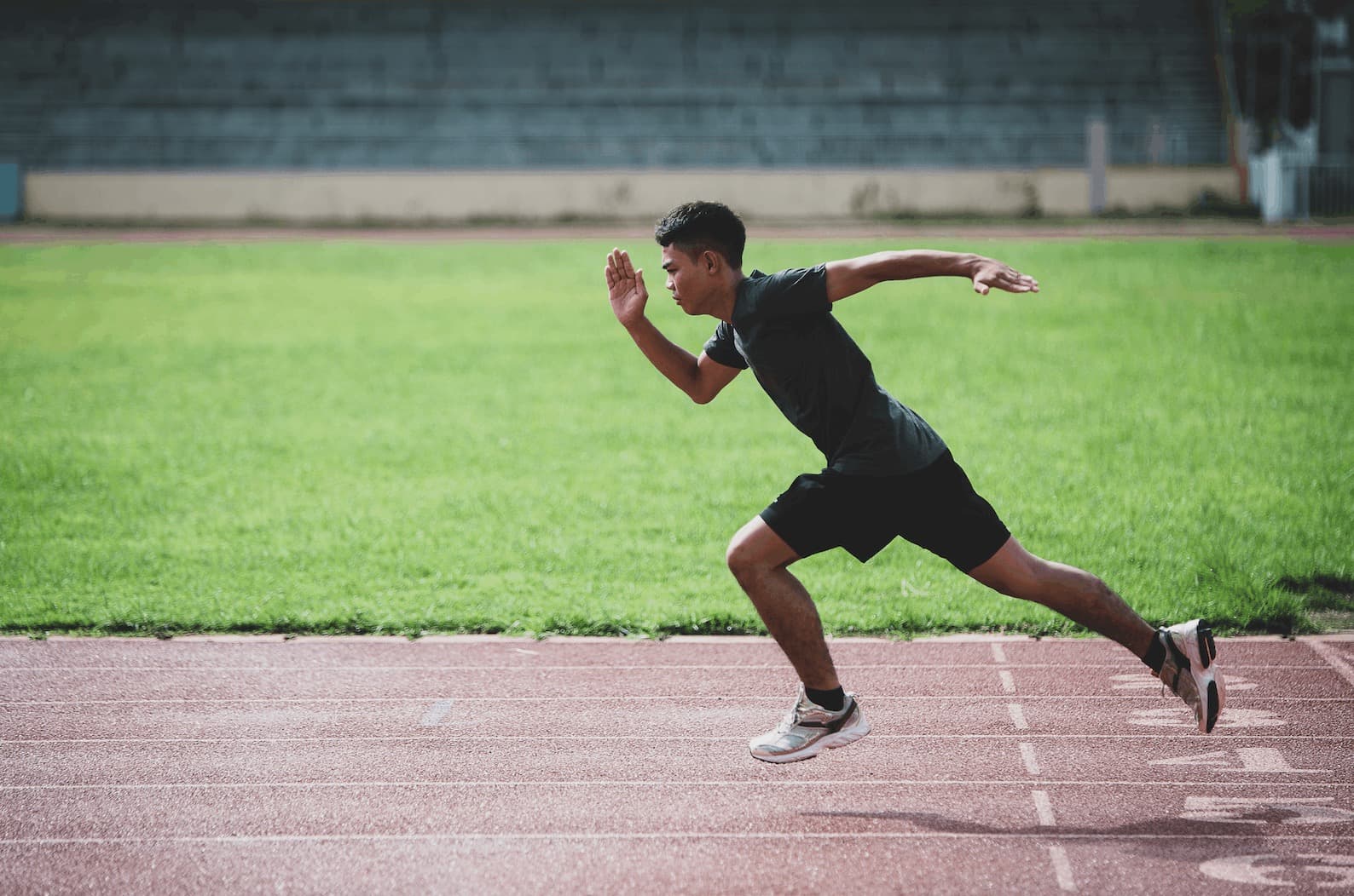 An athlete sprinting at full effort on a track, illustrating sprint interval training for fat loss