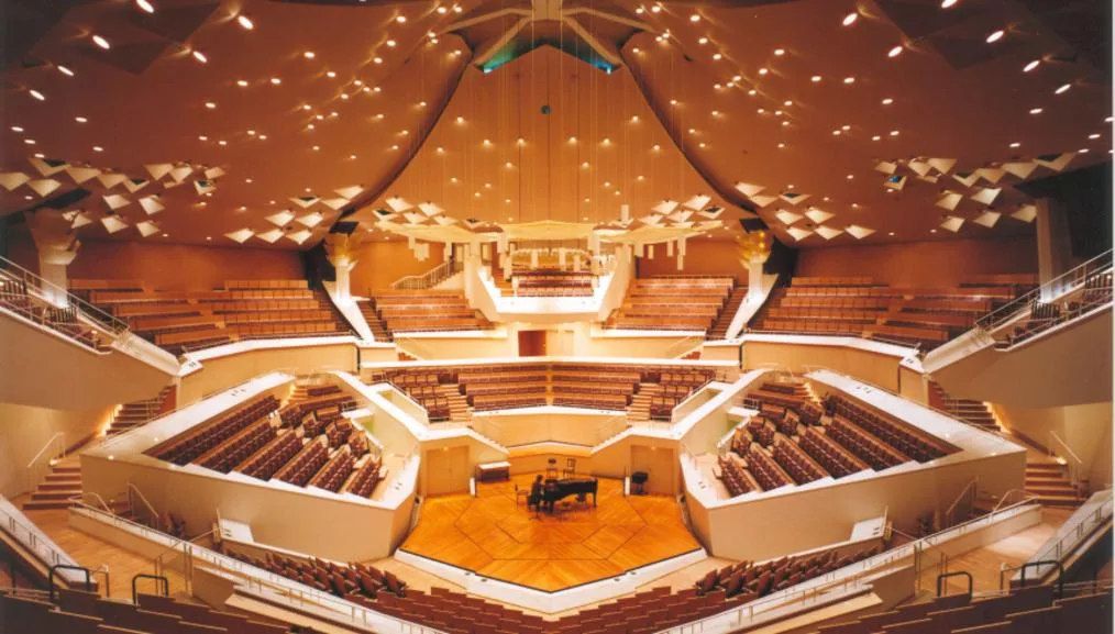 Panoramic view of the Philharmonie Berlin's Grosser Saal, with tiered seating surrounding a central stage and a grand piano