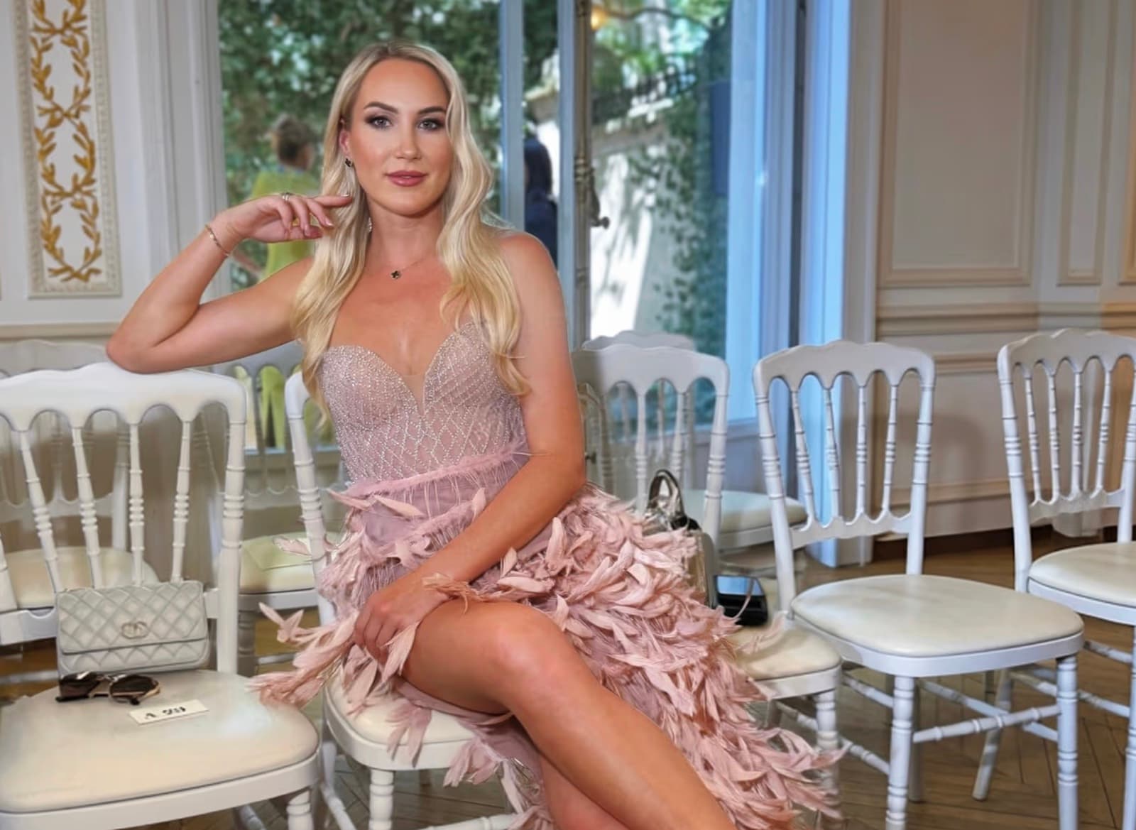 Alyona Iakymchuk seated in a pink feathered couture gown at a Paris Haute Couture Week show