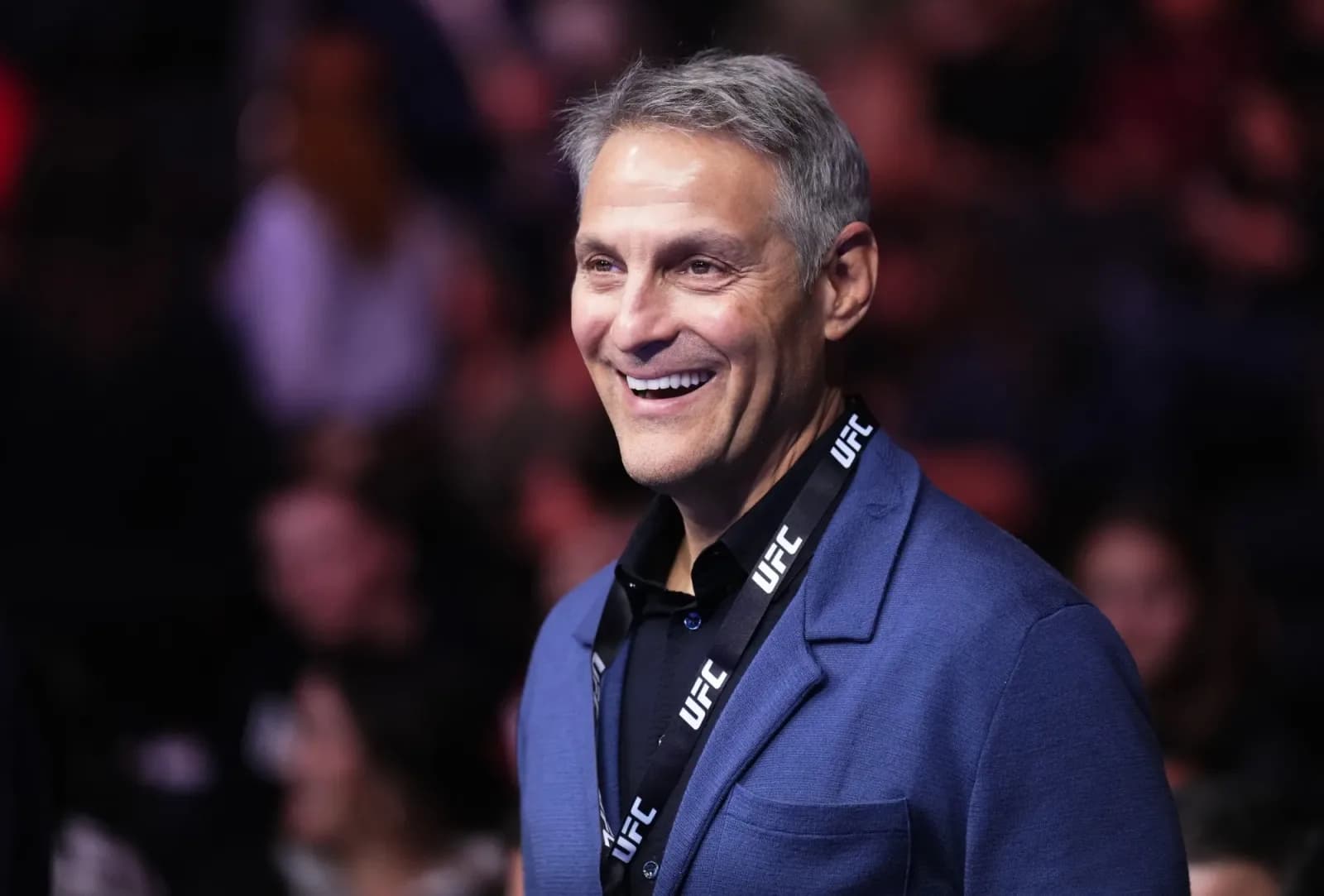 Ari Emanuel smiling in a blue blazer wearing a UFC lanyard