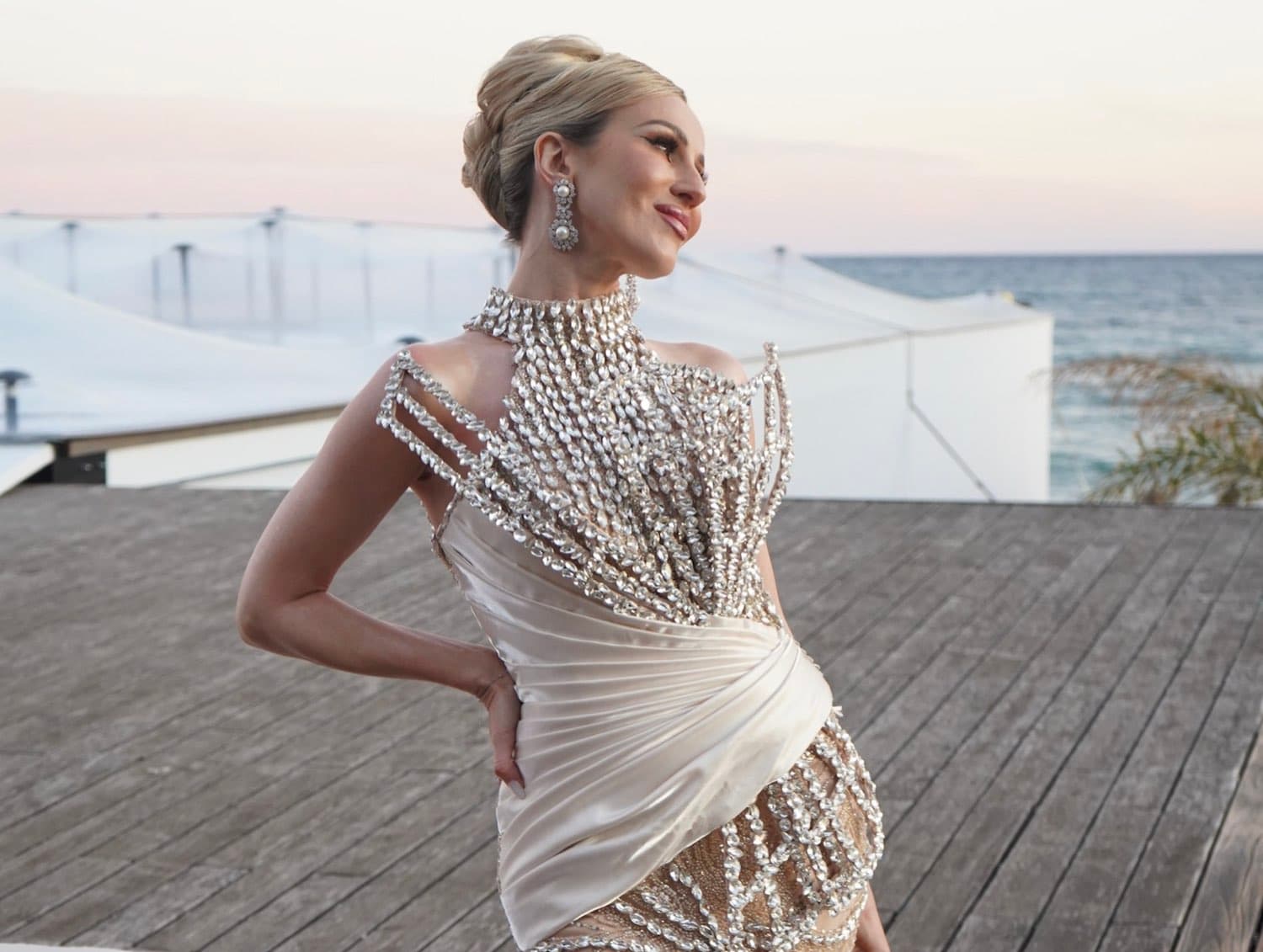 Entrepreneur Irina Biss in a crystal embellished gown at a seaside event at sunset