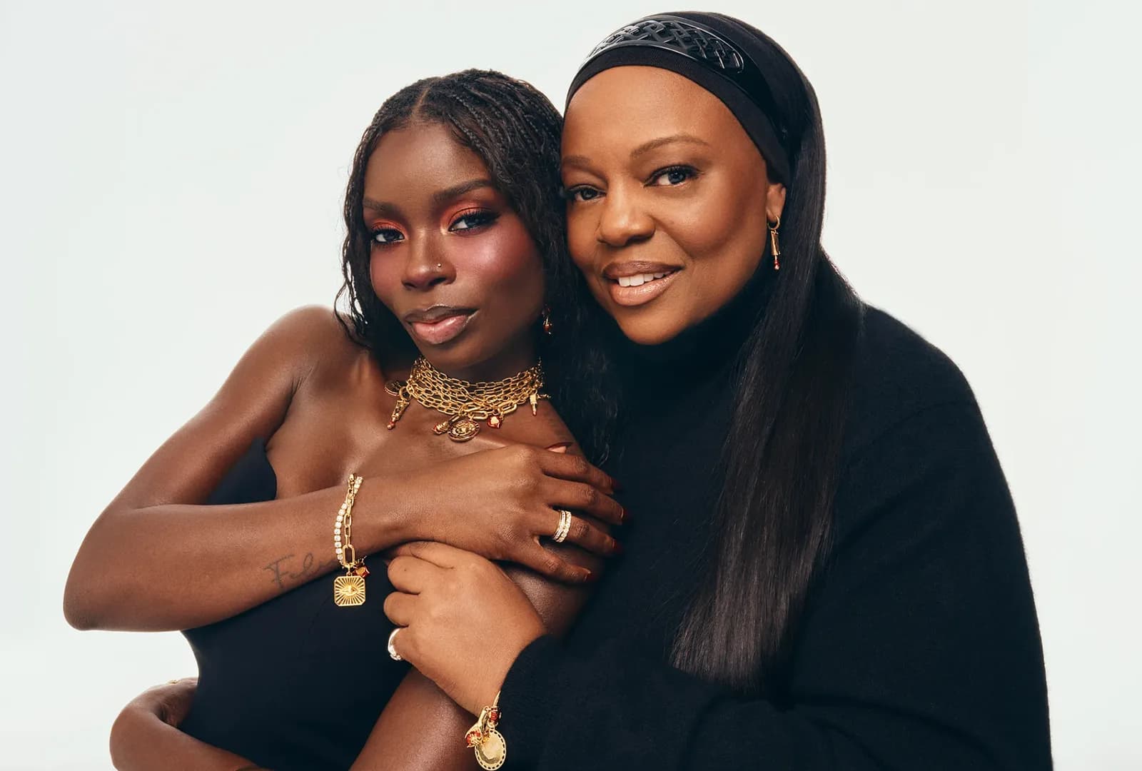 Olandria Carthen and Pat McGrath embracing in black outfits wearing Pandora jewelry